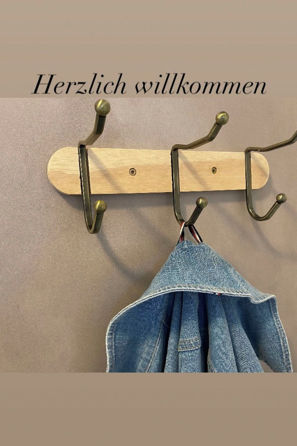 Un porte-manteau en bois, doté de trois crochets, avec un sac en jean suspendu à l’un d’eux.