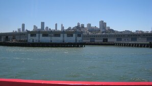 Vista al agua de un horizonte urbano con rascacielos y un muelle.