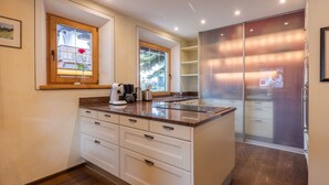 A modern kitchen with a central island, built-in cabinets, and a large refrigerator. - Villa Emma, Ferienhaus für bis zu 10 Personen, eigener Garten, absolute Privats by Interhome (Kaltenbach)