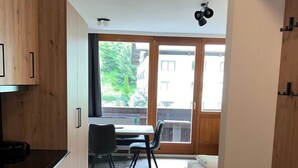 Ett modernt kök med träskåp och en matplats med bord och stolar.