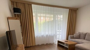En moderne stue med et fladskærms-tv, en sofa og et sofabord.