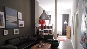 A modern living room with a black sofa, a wooden coffee table, and a bookshelf. - in Wernigerode mit Grill und Garten by Interhome (Wernigerode)