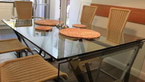 A modern dining area with a glass table and wicker chairs. - in Wernigerode mit Grill und Garten by Interhome (Wernigerode)