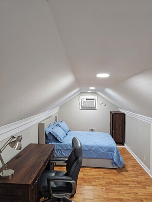 A small, well-lit attic bedroom with a bed, desk, chair, and a wardrobe. - Furnished Atlanta Home Near Airport & Hospitals - Car Available (Atlanta)