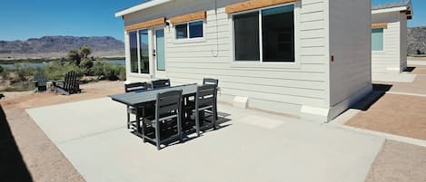 Ett modernt hus med en uteplats, ett bord och stolar.