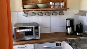 A compact kitchen with a microwave, coffee maker, and a dishwasher. - Ferienanlage Am Sidowsee by Interhome (Fürstenberg)