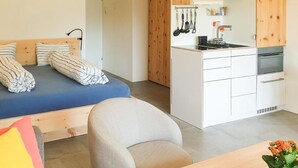 A compact living space with a bed, a small kitchenette, and a seating area. - Rosatsch B15 - Champfèr by Interhome (St. Moritz)