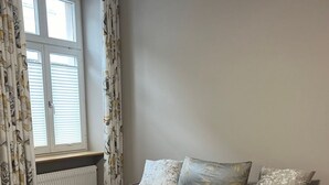 Ein Schlafzimmer mit einem Bett, einem Fenster und Vorhängen.