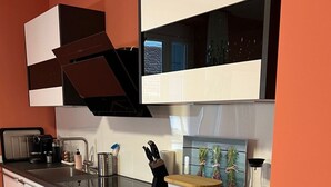 Eine moderne Küche mit weißen Schränken, einer schwarzen Arbeitsplatte und einem eingebauten Ofen.
