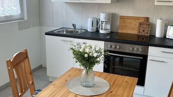 Een koelkast, een microgolfoven, een oven, kookgerei, borden en bestek