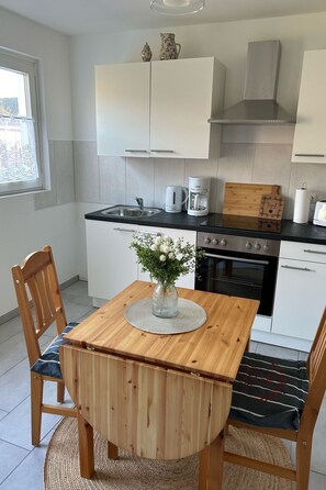 Een koelkast, een magnetron, een oven, kookgerei, borden en bestek