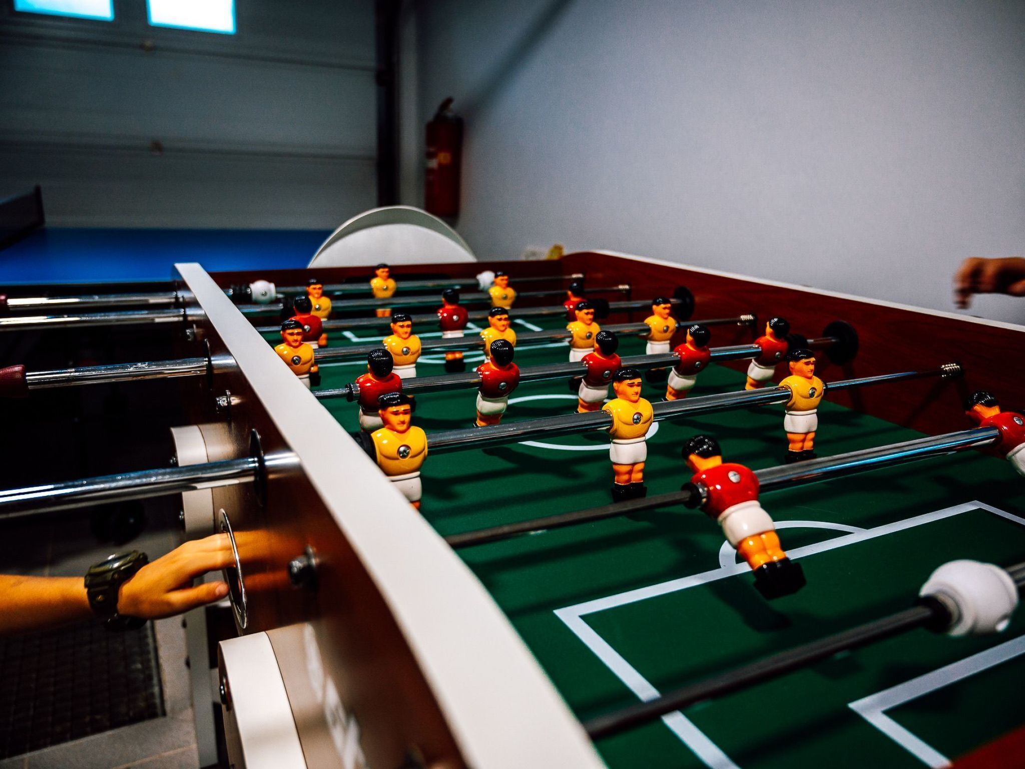 A foosball table with players in red and yellow uniforms.