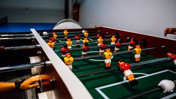 A foosball table with players in red and yellow uniforms.