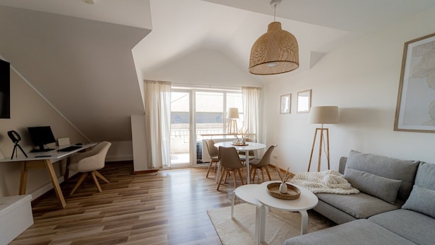 Un apartamento moderno con zona de estar tipo loft, comedor y espacio para trabajar.