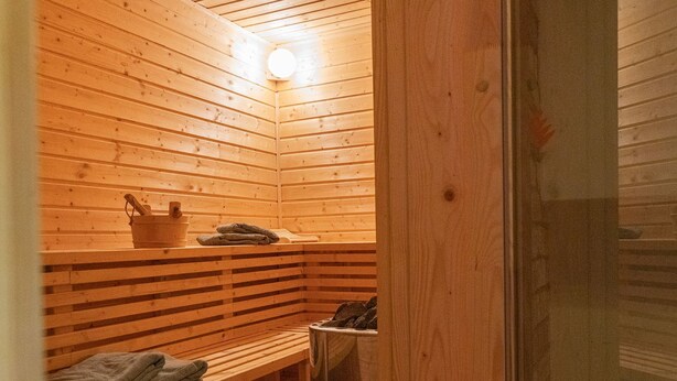 Una sauna con panche in legno e una panca con asciugamani.