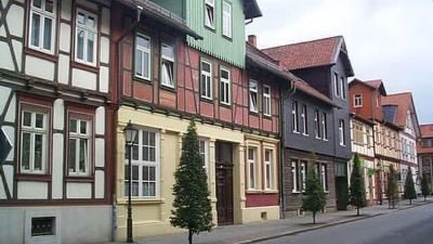 Eine Reihe traditioneller europäischer Gebäude mit markanten architektonischen Details, darunter Fachwerkhäuser und unterschiedliche Fassbenen.