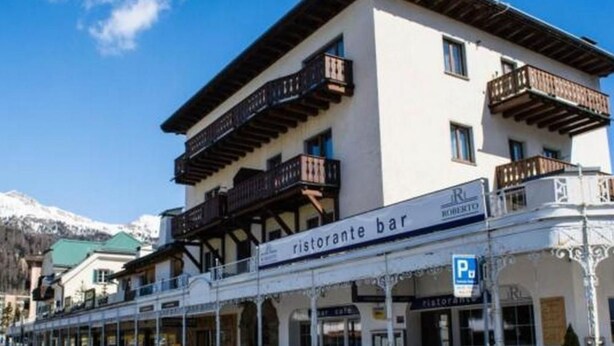 Un edificio con un cartello che indica “ristorante bar” e un segnale di parcheggio.