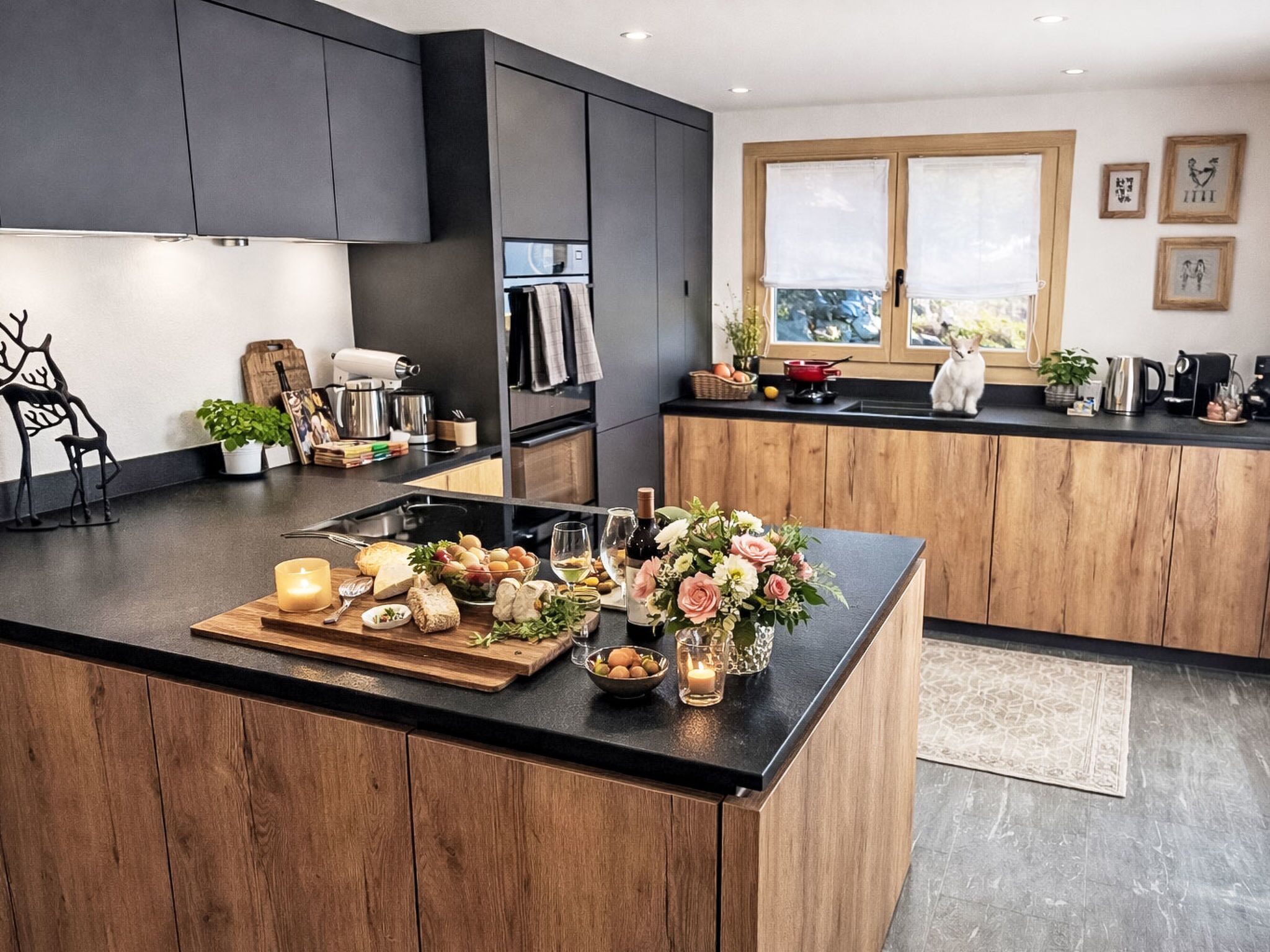 Una cocina moderna con una isla central, armarios de madera y vistas al exterior a través de amplios ventanales.