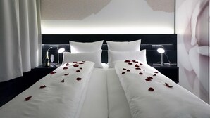 Ein Hotelzimmer mit einem großen Bett, zwei Nachttischen und einem an der Wand befestigten Kunstwerk.
