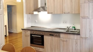 Ett modernt kök med träskåp, en rostfri köksfläkt, en inbyggd ugn och en diskmaskin.