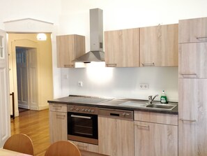 A modern kitchen with wooden cabinets, a stainless steel range hood, a built-in oven, and a dishwasher. - Wohnung in einem historischen Gebäude mit Balkon und Blick auf die Mosel by Interhome (Zell (Mosel))