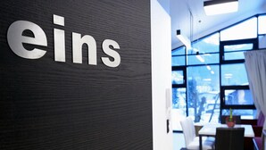 Et moderne interiør med en mørk trævæg og et skilt med teksten "eins".