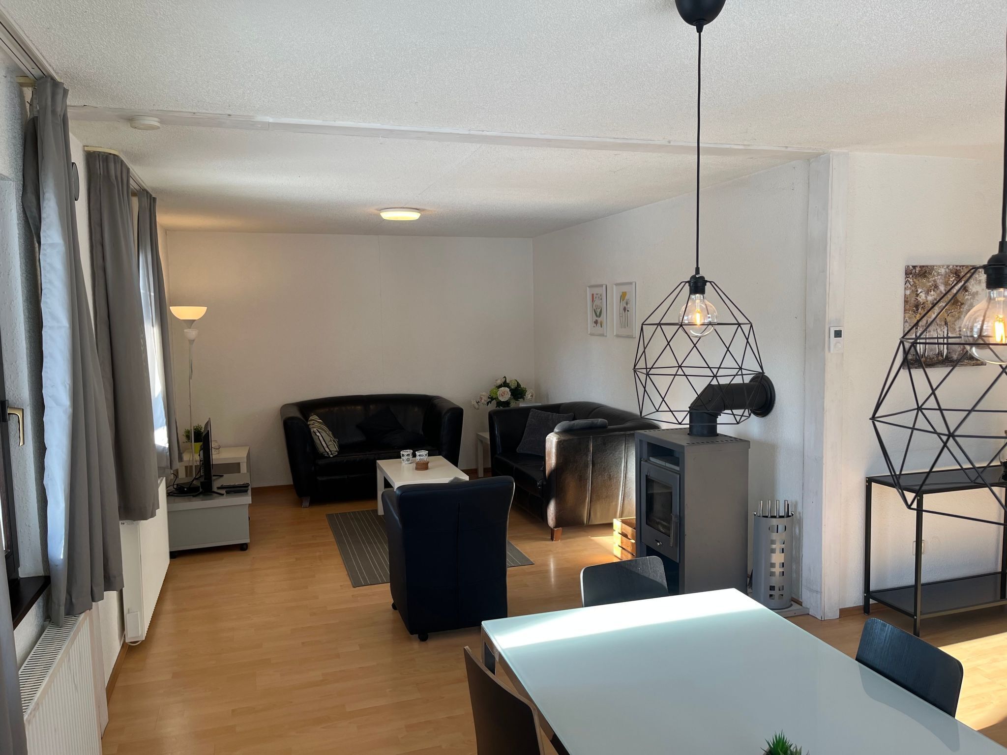 Un salon moderne comprenant un canapé, une table à manger et un coin cuisine avec une cuisinière.