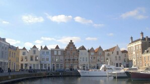 A canal-side view of a row of traditional European buildings with a marina in the foreground. - für 6 Personen ca. 90 m² in Wemeldinge, Zeeland (Zuid-Beveland) by Interhome (Wemeldinge)