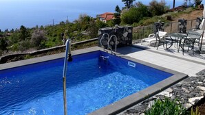A swimming pool with a stone wall and a view of the sea. - Nettes Ferienhaus in Tijarafe mit Privatem Pool und Panoramablick by Interhome (Tijarafe)