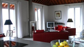 A modern living room with a red sofa, a glass coffee table with fruit, and a television. - Nettes Ferienhaus in Tijarafe mit Privatem Pool und Panoramablick by Interhome (Tijarafe)