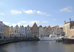 A canal-side view of a row of traditional European buildings with a marina in the foreground. - Familienfreundliches Ferienhaus in Zeeland by Interhome (Wemeldinge)