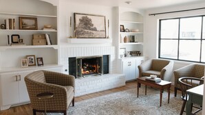 A living room with a fireplace, built-in shelving, and comfortable seating. - NEW Boutique Historical Home Downtown Edmond (Edmond)