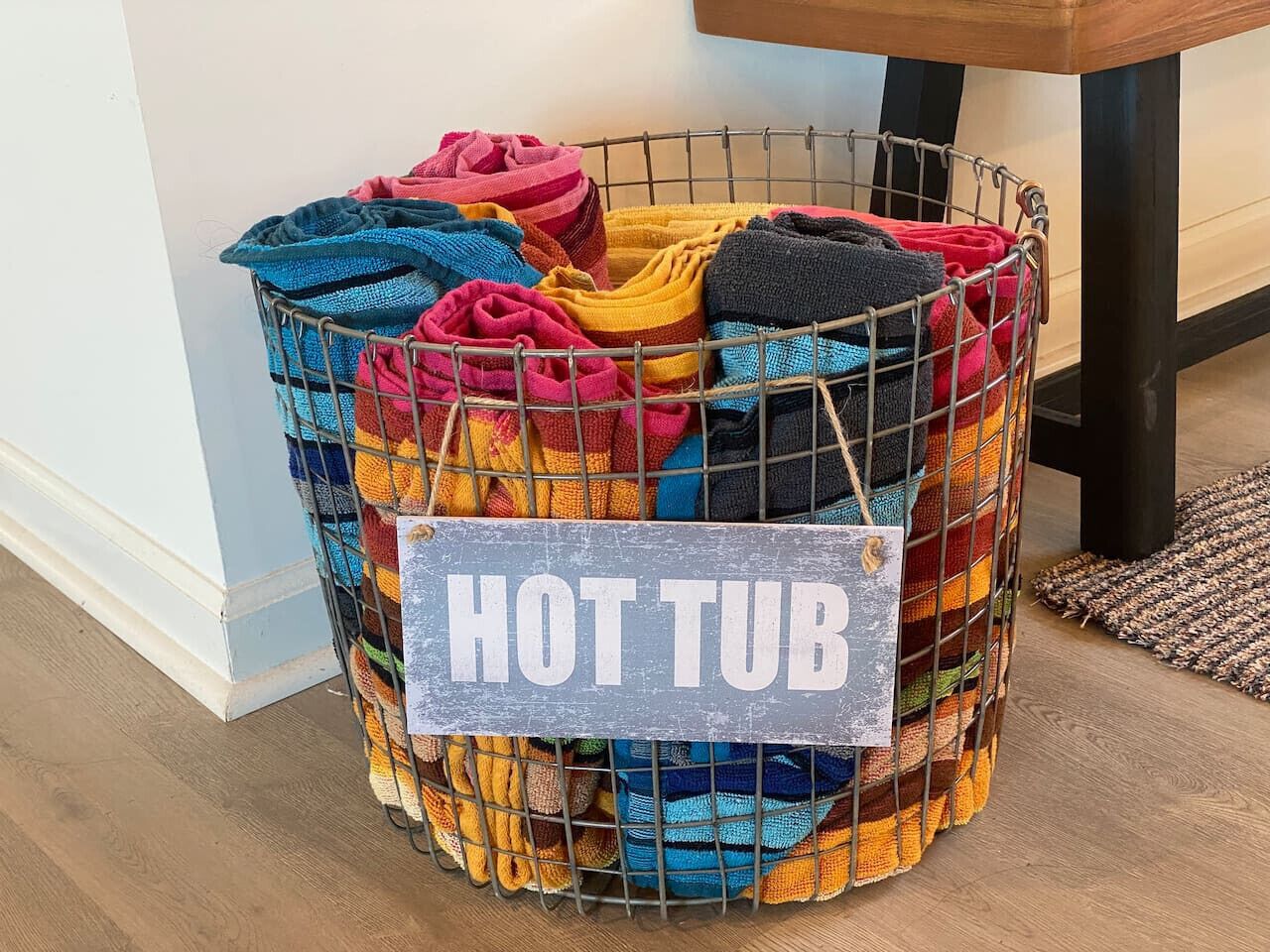 A storage bin labeled "HOT TUB" filled with colorful towels.