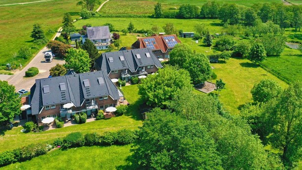 Een woonwijk met meerdere huizen, een heldere lucht en een meer op de achtergrond.