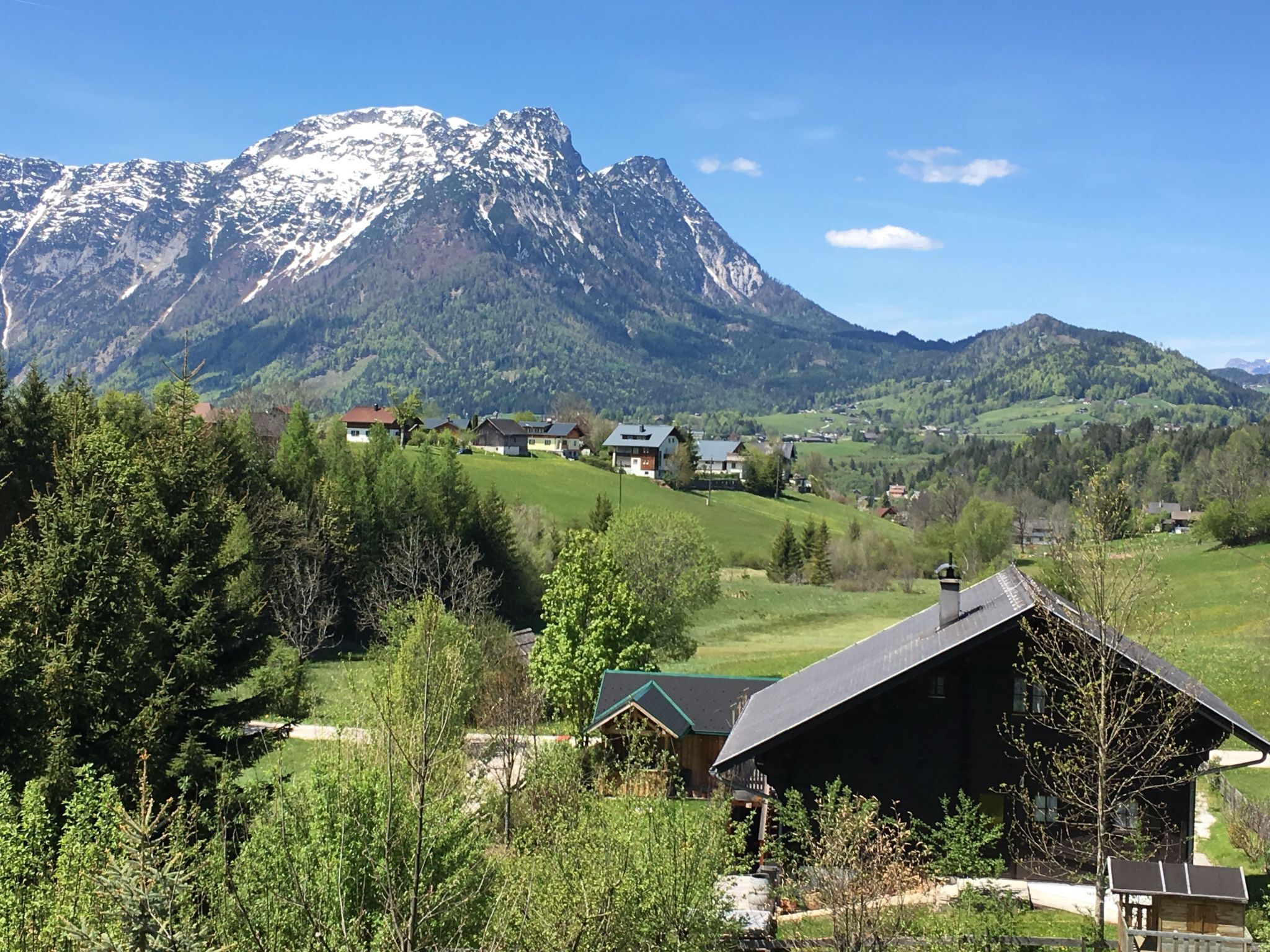 A mountain landscape with houses and a cabin.