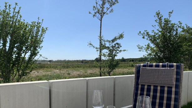 Ein Tisch im Freien mit Blick auf ein Feld und Bäume.