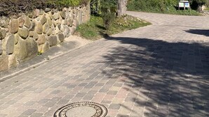 Un camino de piedra que conduce a un edificio histórico con tejado de tejas rojas y una torre.