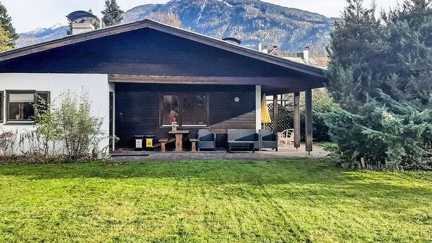 A modern house with a covered patio, a mountain in the background, and a well-maintained lawn. - Haus Fink - Igls by Interhome (Innsbruck)