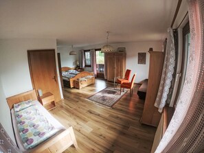 Une chambre à coucher avec un lit, un bureau, une chaise, une armoire et une fenêtre.