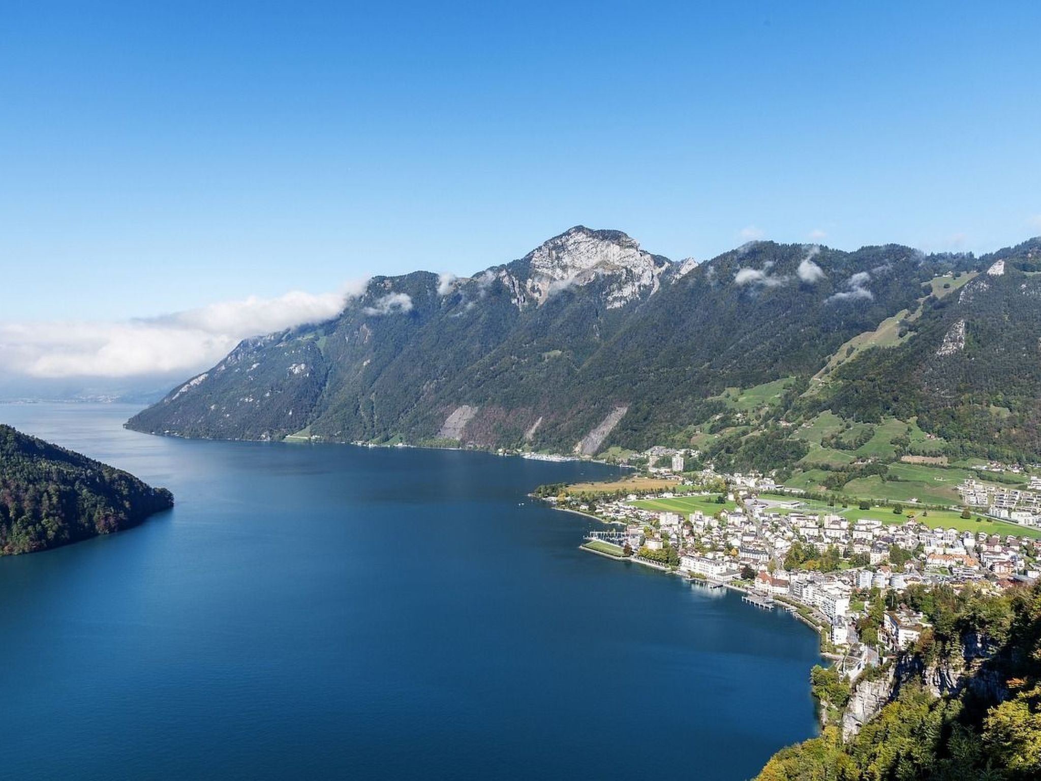 Eine Küstenstadt mit See, Bergen und blauem Himmel.