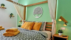 A neatly made bed with a geometric patterned bedspread, two pillows, and a bedside table with a lamp and a plant. - Vista Faro by Interhome (Morro Jable)