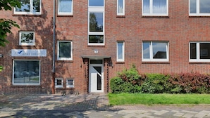 A brick building with multiple windows and a sign indicating it is an apartment complex. - Wattenmeer by Interhome (Wilhelmshaven)