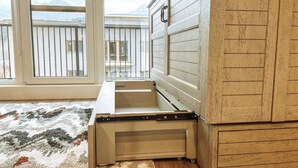 Une pièce avec une grande fenêtre, un buffet en bois et une petite table.
