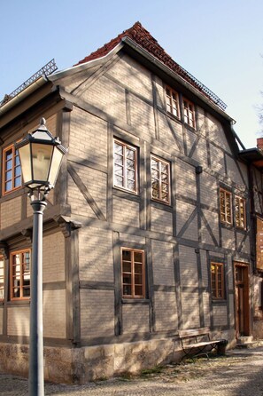 A traditional half-timbered building with multiple windows and a bench in front. - für 2 Personen  + 2 Kinder ca. 70 m² in Quedlinburg, Harz (Unterharz) by Interhome (Quedlinburg)