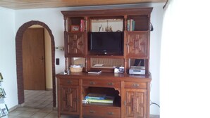 A wooden entertainment center with a television, books, and electronic devices. - Elbufer 4C by Interhome (Marschacht)
