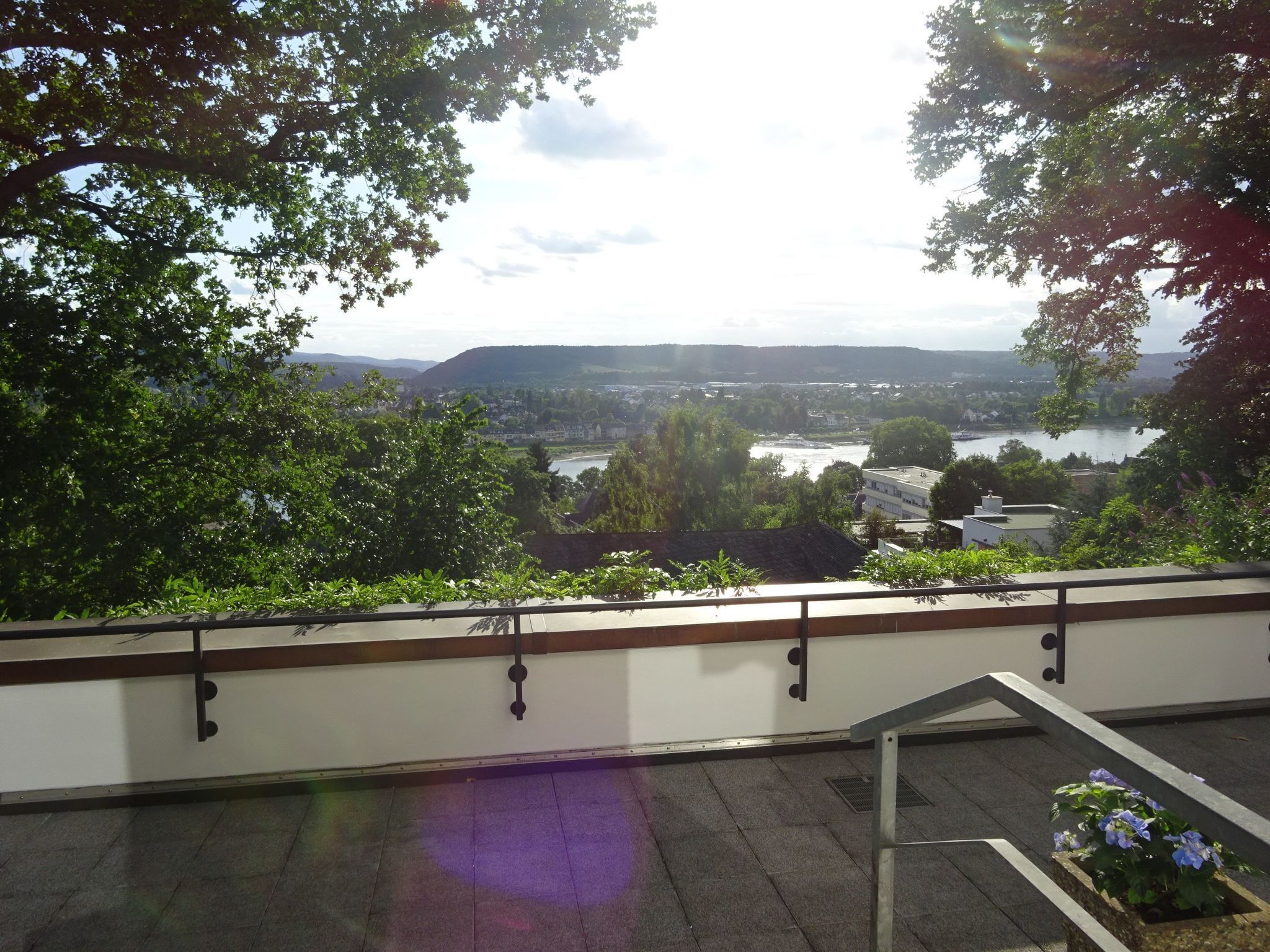 Ein Balkon mit Blick auf einen Fluss und sanfte Hügel in der Ferne.