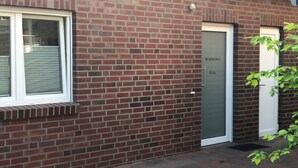 Un edificio in mattoni con una finestra a cornice bianca e una porta con la scritta "Wohnung AAL".