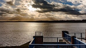 Vista sull'acqua con un molo e una ringhiera.