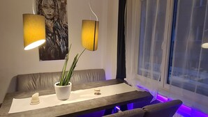 Un espace repas moderne avec une longue table, deux chaises, une plante en pot et deux lampes.
