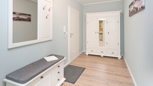 Ein Flur mit einer Bank, einem Kleiderschrank und einer Tür zu einem Badezimmer.